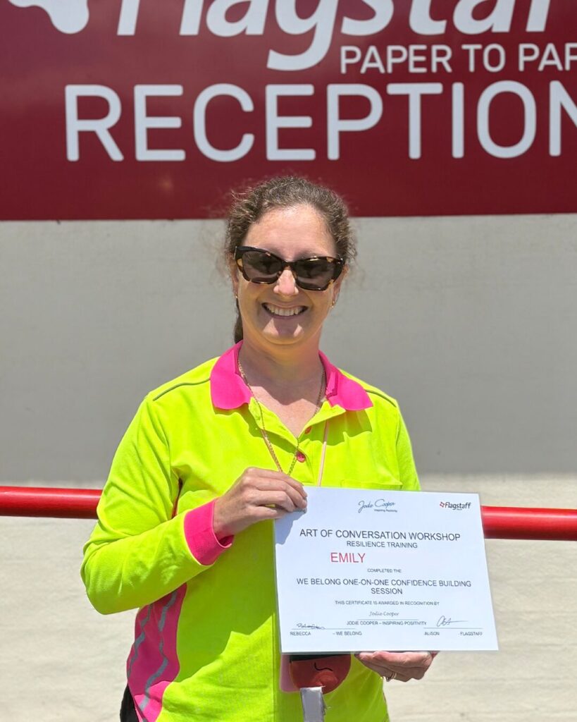 Emily outside. Holding Art of Conversation Workshop Certificate.