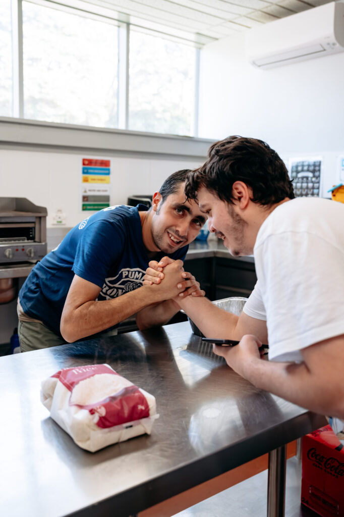 Participants are arm wrestling. Life Choices Kitchen.