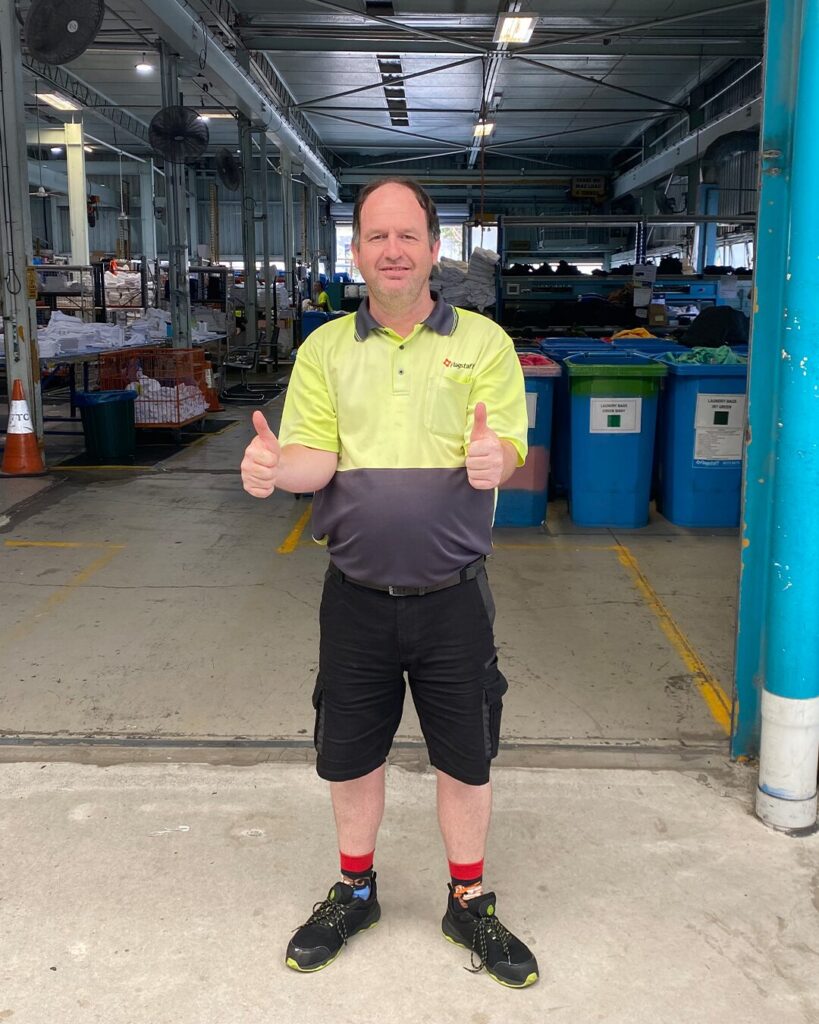 Shawn standing outside of Flagstaff Laundry. Thumbs up.