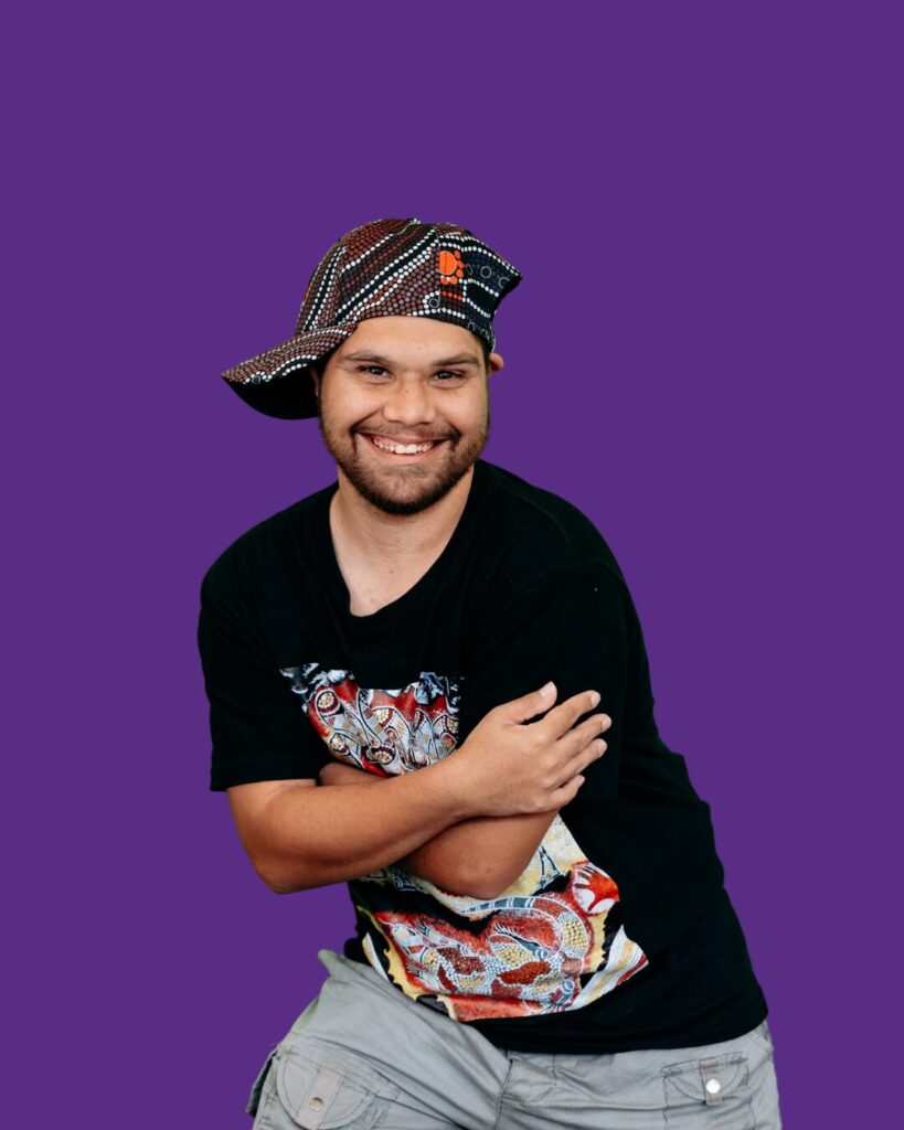 Tel posing. Hat on head. Smiling.