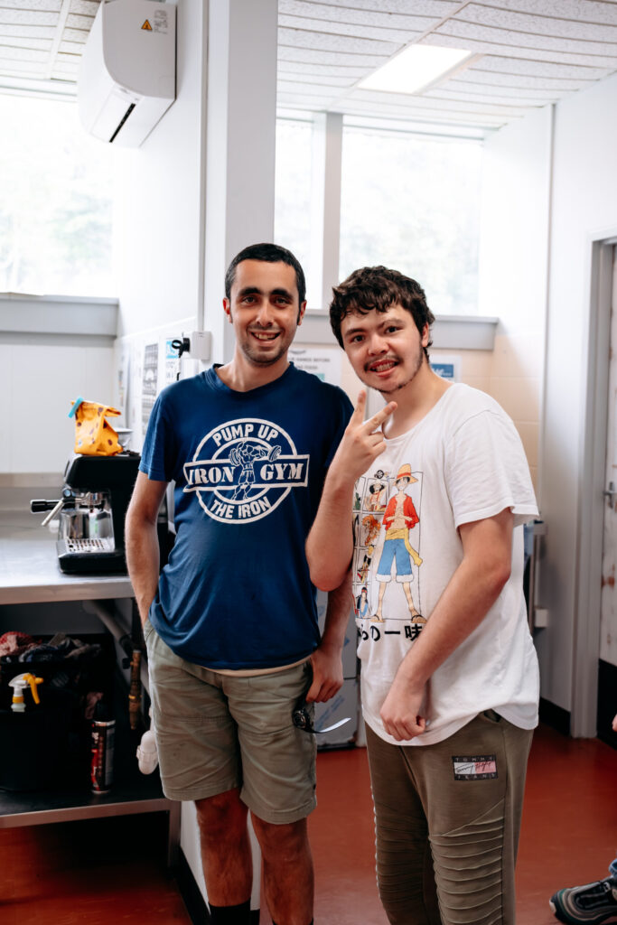 Two participants are standing in the kitchen. We belong program